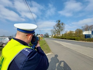 policjant ruchu drogowego mierzy prędkość pojazdów