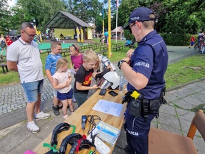 policjantka prezentuje dzieciom policyjny sprzęt