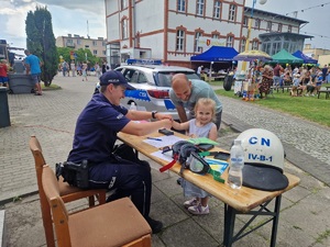 policjantka pomaga dziewczynce zrobić odbitki palców