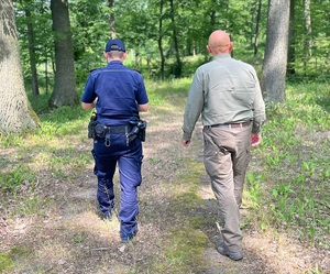 policjant i leśniczy patrolują tereny leśne