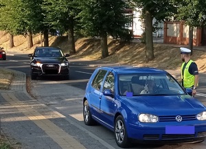 policjant ruchu drogowego kontroluje kierowcę samochodu osobowego