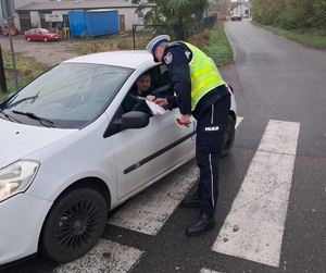 policjant wręcza upominek kierującemu