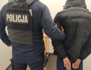 policjant trzyma osobę zatrzymaną