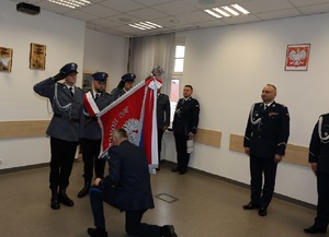 policjant żegna się ze sztandarem