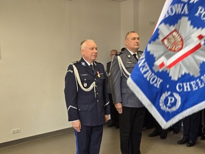 policjanci stoją przed sztandarem
