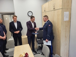 mężczyzna i policjant podają sobie dłoń