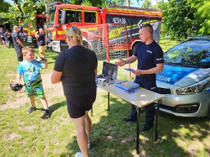 policjant pokazuje chłopcu policyjny sprzęt
