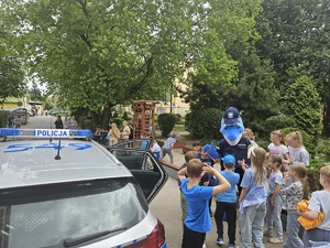dzieci bawią się z policyjna maskotką