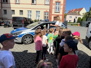 dzieci stoją w kolejce do radiowozu
