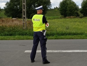 policjant ruchu drogowego nadzoruje ruch na drodze