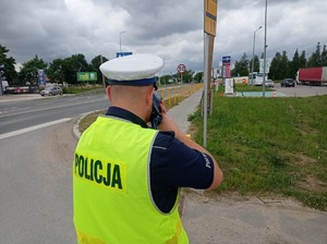 policjant mierzy prędkość jadących pojazdów
