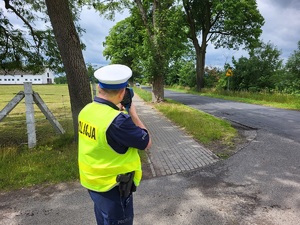 policjant mierzy prędkość jadącego pojazdu