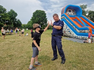 policjant z chłopcem przybijaja sobie piątkę