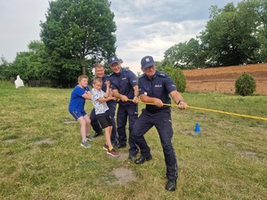 policjanci z chłopcami ciągną linę