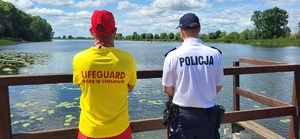policjant i ratownik wodny obserwują jezioro