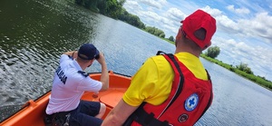 policjant i ratownik obserwują teren jeziora